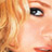 Pixelated close-up of a person's face with visible eye, hair, and partial facial features in warm tones.
