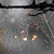A static pixelated image shows a dark horizontal bar across the top with blurred light and dark shapes below, including faint circular highlights on a gray background.