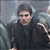 Pixelated image of a person in dark clothing holding a white object against a blurred background.