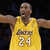 A basketball player in a yellow jersey with number 24 and 'Lakers' text, arms extended horizontally against dark background.