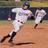 Baseball player in white uniform running on dirt field with blurred motion effect, paired with pixelated text about fear of striking out.
