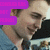 Pixelated image of a person with light hair wearing a dark top, partially obscured by a purple text box with pink lettering.