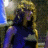 A 48x48 pixel animated contact sheet showing two frames of a woman with blonde hair in a dark blue sleeveless dress against a blurred background, with visible motion between the left and right frames.