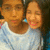 Two people in light blue shirts pose closely together, with one person's arm around the other's shoulder, in a pixelated image with visible animation changes.