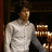 Pixelated image of a person in a light-colored shirt holding a stack of brown objects, with purple text reading 'nick jonas is a stud muffin' on a light background.