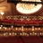 Static image of a theater interior with red seating, wooden paneling, and a large illuminated stage area.