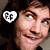 A person with dark hair and light skin appears in a of four , wearing a white heart-shaped icon with 'FF' text on the left side