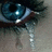 A pixelated close-up of a human eye with visible tears on the lower eyelid, set against a teal background with blue text reading "i know it shouldnt matter but i cant help it".
