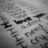 Grayscale pixelated image with scattered dark shapes on a light background, no discernible subjects or text.
