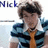 Pixelated static image of a person with dark hair wearing a blue and black jacket over an orange shirt, partially visible text 'Nik' in the top-left corner.
