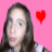 Pixelated image of a person with long dark hair against pink background, red heart symbol to right.