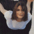 A pixelated image of a person with long brown hair wearing a white shirt and dark jacket, arms raised against a green background with 'OriginalIcons.com' text.