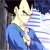 Pixelated figure in blue clothing with dark hair, light-colored face showing closed eyes and a slight smile against a gradient background.
