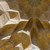 Pixelated static image with brown and beige tones showing indistinct shapes and light reflections on a textured surface.