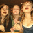 Three pixelated figures with light skin and brown hair stand side-by-side, mouths open in laughter against a dark background.