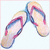Two flip-flops with pink and blue straps on a light background, next to a pink square containing pixelated text.