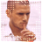 Pixelated static image of a man with short hair holding his finger to his lips in a shushing gesture, set against a light pink grid background.