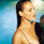 Pixelated image of a woman with long dark hair in profile, wearing a light-colored strapless top against a blue and white background.