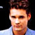 Static 50x50 pixel icon showing a close-up of a person's face with dark hair and light skin, wearing a white collared shirt against a black background.