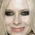 A pixelated image of a person with light hair and dark eye makeup, holding a pink heart-shaped object above their head.