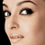 Pixelated close-up of a person's face showing eyes, nose, and mouth against a black background.