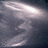 A static pixelated image with a dark background and light streaks resembling motion blur or abstract shapes.