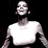 Pixelated static image of a person in a white shirt against black background with visible dithering and low-resolution rendering artifacts.