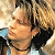 Four distinct pixelated portraits of a person with light brown hair in various poses and angles, displayed as separate