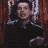 A pixelated animation of a person in dark clothing against a red curtain background, showing sequential mouth and hand movements.