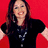 Pixelated image of a person with long dark hair wearing a black top and silver necklace against a solid red background.