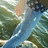 Pixelated landscape with blue water, green foliage, and light brown sky elements in a low-resolution static image.