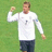 Two identical figures in white long-sleeve shirts and dark shorts stand on a green field, one with a raised fist, the other with a raised hand, both facing forward.