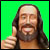 Pixelated image of a person with long dark hair and beard giving a thumbs-up gesture against bright green background.