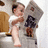 A pixelated cartoon figure sits on a toilet with arms crossed, wearing a white top and dark skirt, with red text above reading "A BAY BAY".