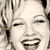 Pixelated close-up of a smiling face with closed eyes, showing a wide open mouth and visible teeth, set against a blurred background with vertical lines.