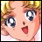 Pixelated anime-style character face with blonde hair, wide blue eyes, and open mouth on left; black background with white text on right.