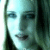 Pixelated face with light blue and dark green tones, featuring visible eyes, nose, mouth, and partial hair against a bright background.