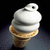 Pixelated image of a single ice cream cone with white soft-serve swirls atop a brown waffle cone against dark background.