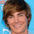 Pixelated close-up of a person with brown hair against a light blue background, smiling with visible teeth.