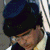 A four- shows a person with dark hair in different poses: wearing a blue cap, holding a microphone, and speaking into it
