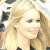 A pixelated image of a person with long blonde hair and light skin, next to green text on a dark background.