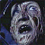 Pixelated grayscale image of a stylized skull with hollow eye sockets and a wide open mouth, set against a dark background with blue and purple pixel clusters.