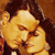 Two figures in close physical proximity with eyes closed, rendered in warm-toned pixelated style against a brown background.