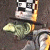A contact sheet of two animated frames showing a pixelated character with checkered eyes and yellow accents on the left, next to green text reading "Original Icons .com" on a dark background.