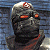Pixelated character with metallic helmet and red emblem, orange glowing eyes, dark armored body against blue background; green text 'Original Icons .com' on right.