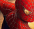 A pixelated close-up of a red and black figure with glowing yellow eyes against a blurred background.