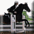 Pixelated static image shows two figures in dark clothing on a white horse, one figure holding reins with green foliage background.