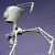 Pixelated grayscale figure with elongated limbs and a rounded head, standing against a solid purple background.