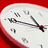 A clock face with black hands and numerals on a white dial against a red background, with text overlay reading "Only time can mend" in red and black.