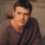 Four of a person in a brown long-sleeve shirt against a light textured background showing subtle facial and head position changes